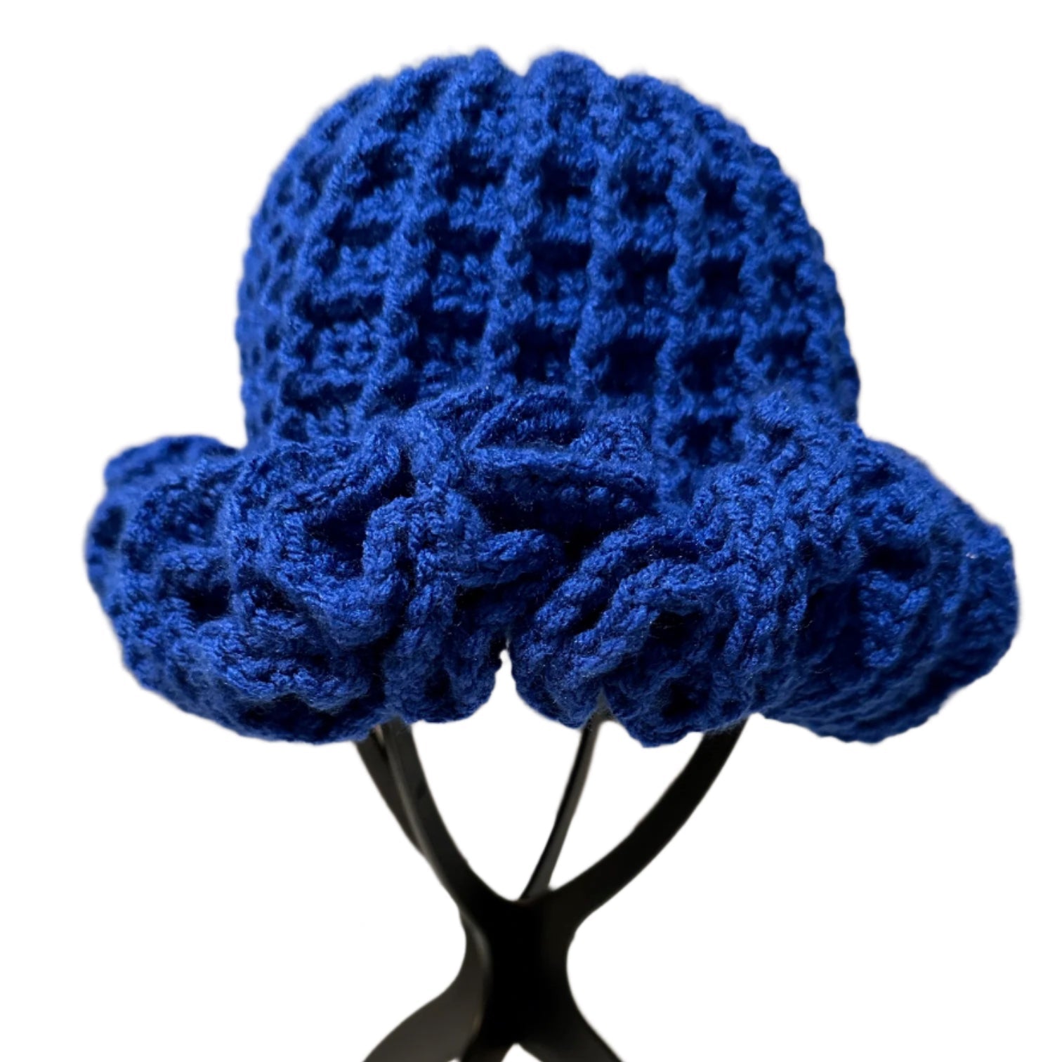 Handmade blue ruffle hat with textured knit design displayed on black stand