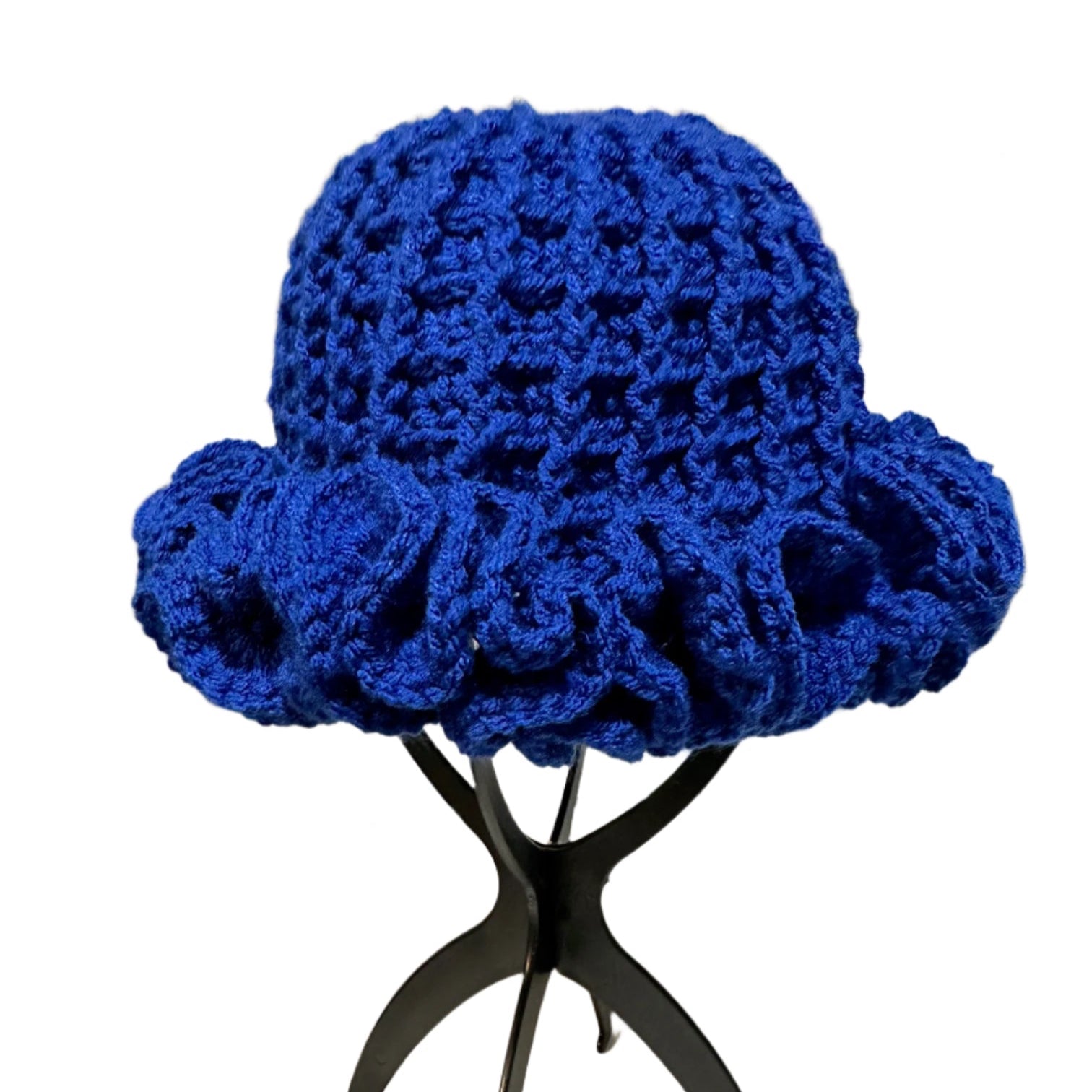 Handmade blue ruffle hat with textured crochet design displayed on black stand