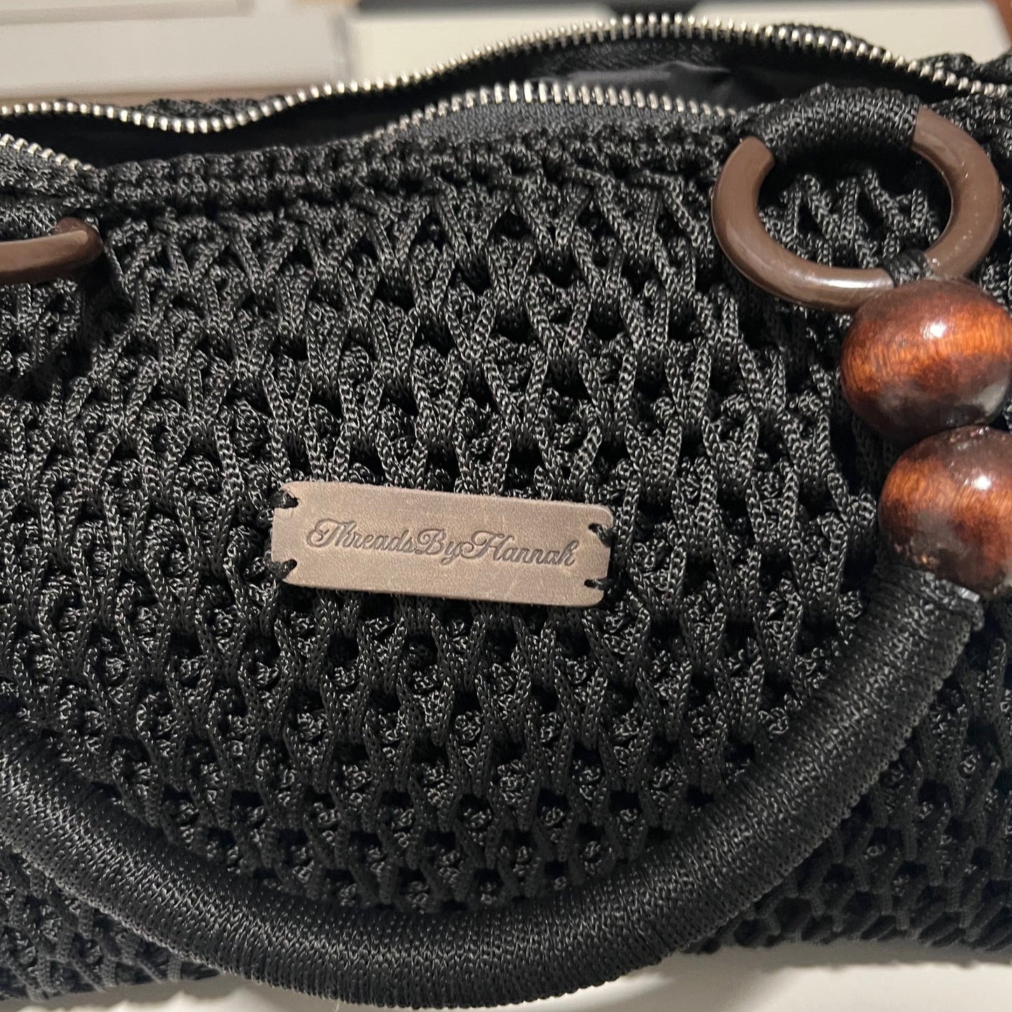 African handmade crochet Sling handbag by ThreadsByHannah featuring unique design and wooden accents