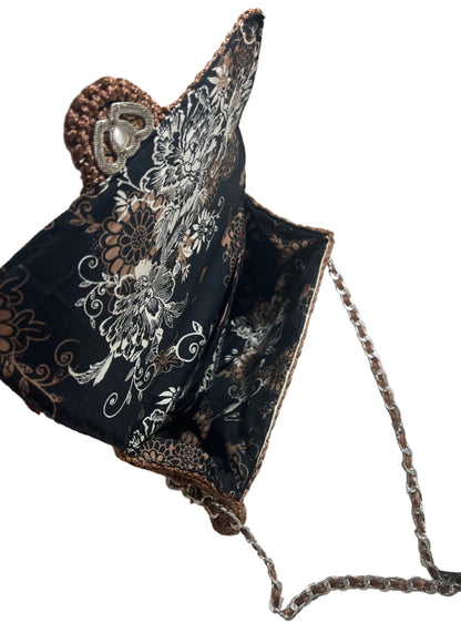 Artisan woven evening purse in black with floral design and silver chain strap for stylish occasions