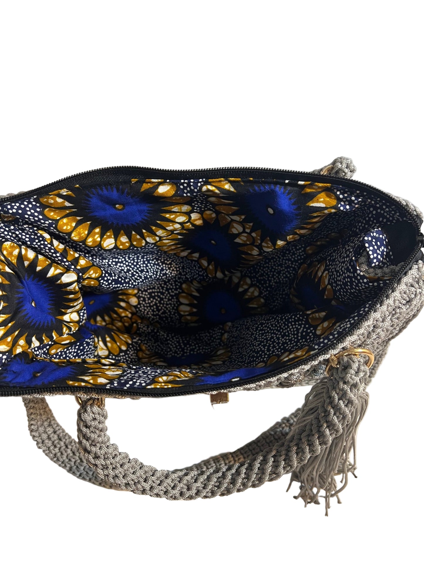Inside view of grey crochet shoulder bag for women with colorful patterned lining and zipper closure