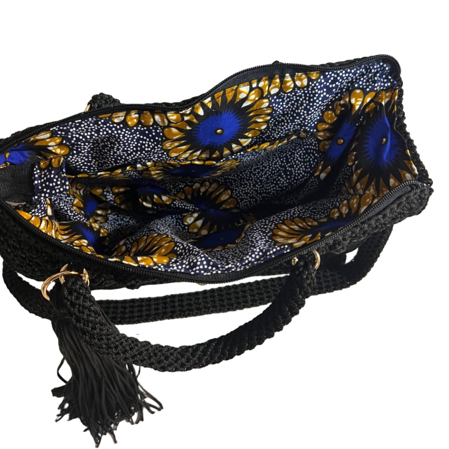 Handcrafted black sling handbag featuring a colorful interior with floral patterns and braided straps
