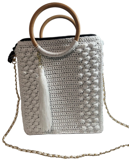 Handcrafted trapezoid handbag with wooden handle and tassel detail in stylish crochet design