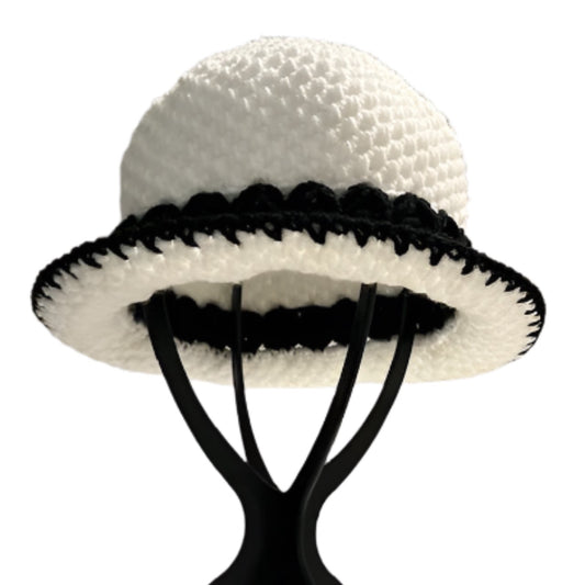 Handmade black and white bucket hat displayed on black stand by ThreadsByHannah
