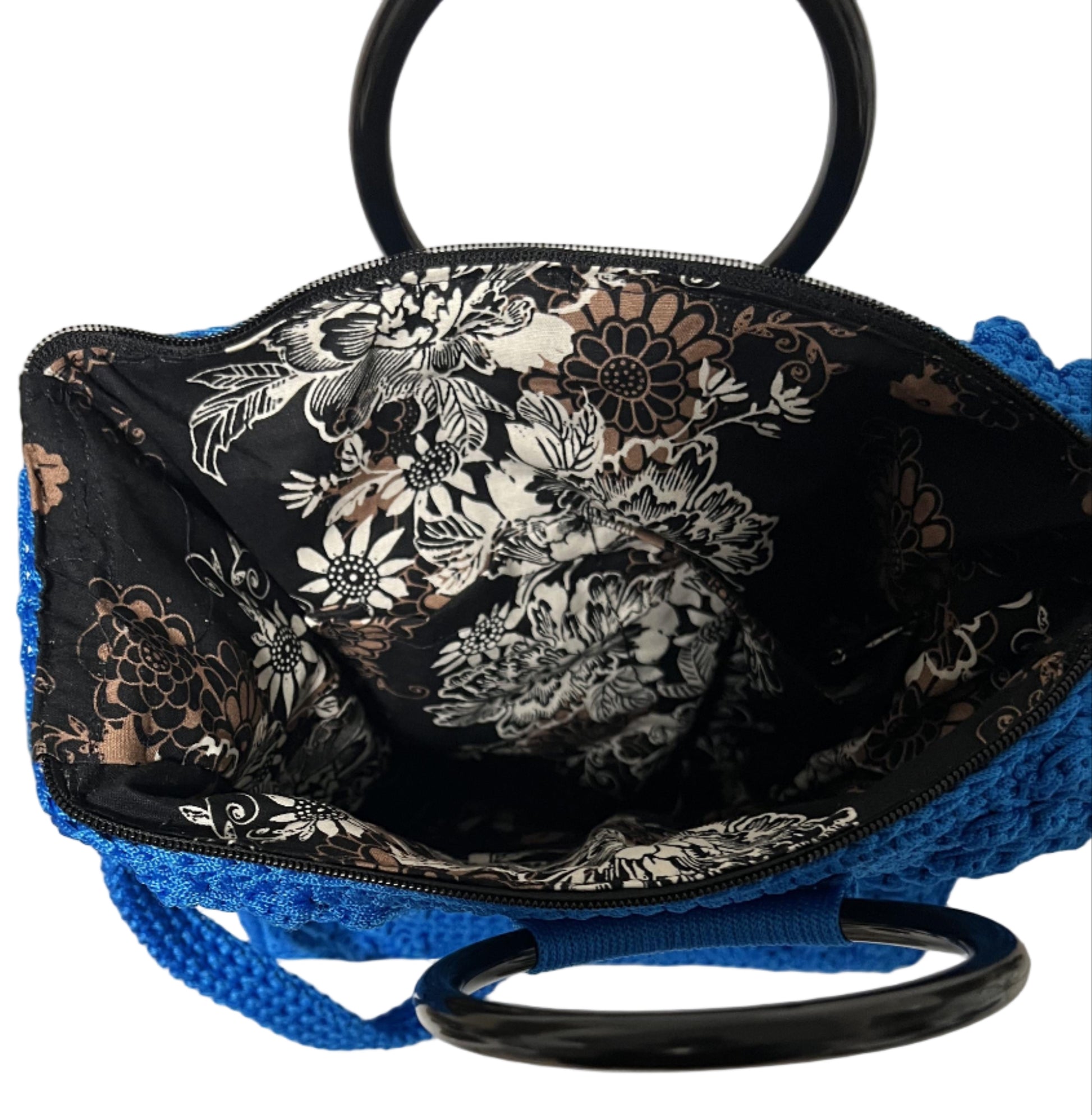 Interior view of Handmade Blue Crochet Trapezoid Handbag with floral lining and black handles