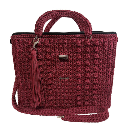 Handmade red sling handbag with a textured design and tassel accessory for stylish carry
