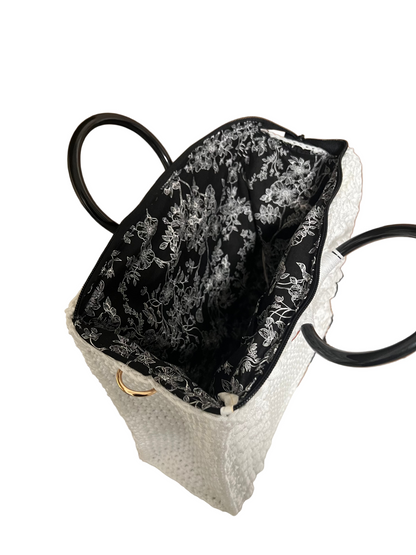 Inside view of a white boho satchel bag for women with floral black lining and sturdy handles